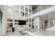 Bright open-plan living room with soaring ceilings, mirrored accent wall and a modern staircase at 7024 Bradbury Cir, Wesley Chapel, FL 33545