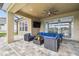 An outdoor patio has a TV, comfortable seating, and a view of the backyard at 7024 Bradbury Cir, Wesley Chapel, FL 33545