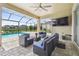 Outdoor seating area with a ceiling fan overlooks the relaxing screened-in pool at 7024 Bradbury Cir, Wesley Chapel, FL 33545