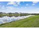 Beautiful pond view showcasing lush grass and calm waters, reflecting the sky at 7024 Bradbury Cir, Wesley Chapel, FL 33545