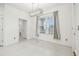Bright room featuring a window with blinds, tile floor, modern lighting, and entryways to other rooms at 7024 Bradbury Cir, Wesley Chapel, FL 33545