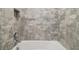 Close-up of a tiled shower showcasing the shower head, sleek fixtures, and convenient built-in niche at 7024 Bradbury Cir, Wesley Chapel, FL 33545