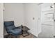 Cozy sitting area features comfortable blue chair and adjacent black table with decor, next to the bedroom entry at 7024 Bradbury Cir, Wesley Chapel, FL 33545