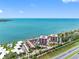 Stunning aerial view showcasing waterfront condos with bay views, lush landscaping, and a sparkling community pool at 7430 Sunshine Skyway S Ln # 602, St Petersburg, FL 33711