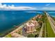 Picturesque aerial view of beachfront condominiums with a pool, docks and easy access to the highway at 7430 Sunshine Skyway S Ln # 602, St Petersburg, FL 33711