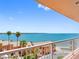 Expansive balcony view overlooking palm trees, the bay, and neighboring orange condo community at 7430 Sunshine Skyway S Ln # 602, St Petersburg, FL 33711