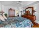 This bedroom features a ceiling fan, a wardrobe, and light-colored wood flooring at 7430 Sunshine Skyway S Ln # 602, St Petersburg, FL 33711