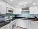 Bright kitchen featuring white cabinets, dark countertops, modern appliances and under cabinet wine rack at 7430 Sunshine Skyway S Ln # 602, St Petersburg, FL 33711