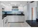 Well-lit kitchen with white cabinetry, tiled backsplash, and modern appliances for an inviting cooking space at 7430 Sunshine Skyway S Ln # 602, St Petersburg, FL 33711