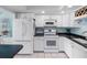 Modern white kitchen features stainless steel appliances, dark countertops, and ample cabinet space at 7430 Sunshine Skyway S Ln # 602, St Petersburg, FL 33711