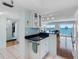 Modern kitchen layout with dark countertops, white cabinets, and open access to the living area and water views at 7430 Sunshine Skyway S Ln # 602, St Petersburg, FL 33711