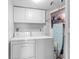 Functional laundry room equipped with a washer, dryer, and overhead storage cabinets at 7430 Sunshine Skyway S Ln # 602, St Petersburg, FL 33711