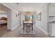 Elegant dining room with modern light fixture, and view to the fenced yard through sliding glass doors at 744 53Rd N Ter, St Petersburg, FL 33703