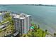 An aerial view showing the building's pool, balconies, nearby buildings, parking and waterfront views at 80 Rogers St # 2D, Clearwater, FL 33756