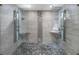Luxurious walk-in shower with dual shower heads, pebble floor, and tiled walls at 80 Rogers St # 2D, Clearwater, FL 33756