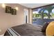Cozy bedroom features art and a balcony with views of tropical trees and parking at 80 Rogers St # 2D, Clearwater, FL 33756