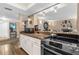 Kitchen with modern stainless steel appliances, sleek white cabinets, and an open view into the dining room at 80 Rogers St # 2D, Clearwater, FL 33756