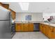 This is a kitchen with stainless steel appliances, wooden cabinets, and a countertop with a sink at 80 Rogers St # 2D, Clearwater, FL 33756