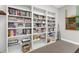 This is a library room with multiple bookshelves filled with books and billiard sticks on the wall at 80 Rogers St # 2D, Clearwater, FL 33756
