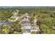 An aerial view shows homes with trees and water in the background on a clear, sunny day at 8074 37Th N Ave, St Petersburg, FL 33710
