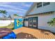 View of backyard with a wood deck, blue butterfly accent wall, and french doors at 8074 37Th N Ave, St Petersburg, FL 33710