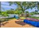 Spacious backyard with a well-maintained lawn, wooden storage sheds, privacy fence, and a partially covered hot tub at 8074 37Th N Ave, St Petersburg, FL 33710