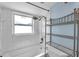 Bright bathroom featuring white tile, a shower-tub combo, and metal shelving at 8074 37Th N Ave, St Petersburg, FL 33710