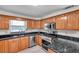 Well-lit kitchen with granite countertops, stainless steel appliances and wood cabinets at 8074 37Th N Ave, St Petersburg, FL 33710