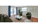 A bright living room features stylish seating, including green chairs and a modern glass coffee table at 8074 37Th N Ave, St Petersburg, FL 33710