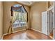 Cozy bedroom featuring an arched window, decorative curtains, and wood flooring at 9242 Brindlewood Dr, Odessa, FL 33556