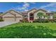 Charming single-Gathering home featuring a manicured lawn, mature landscaping, and a welcoming three-car garage at 9242 Brindlewood Dr, Odessa, FL 33556