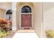Inviting entryway showcases double doors, arched windows, and colorful plants at 9242 Brindlewood Dr, Odessa, FL 33556