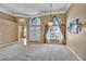 Bright living room featuring neutral paint, high ceilings, large windows, and elegant chandelier at 9242 Brindlewood Dr, Odessa, FL 33556