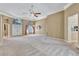 Expansive living area with neutral tones, carpeting, and access to kitchen and entryway at 9242 Brindlewood Dr, Odessa, FL 33556