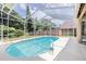 Inviting screened-in pool with lush landscaping and ample patio space for entertaining at 9242 Brindlewood Dr, Odessa, FL 33556