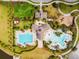 Aerial view of a community pool with a clubhouse, playground, and well-maintained landscaping at 9437 Lemon Drop Loop, Sun City Center, FL 33573