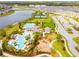 Aerial view of a community with a pool, playground, tennis courts, and a lake at 9437 Lemon Drop Loop, Sun City Center, FL 33573