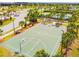 Aerial view of a well-maintained basketball court with palm trees and nearby tennis courts at 9437 Lemon Drop Loop, Sun City Center, FL 33573