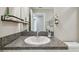 Bathroom featuring a white sink with granite countertop, a mirror, and decorative wall accents at 9437 Lemon Drop Loop, Sun City Center, FL 33573