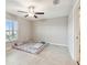 Room featuring neutral-colored tile floors, a large window with blinds, and overhead fan at 9437 Lemon Drop Loop, Sun City Center, FL 33573