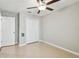 Bedroom featuring a ceiling fan, closet doors, and neutral-colored tile floors at 9437 Lemon Drop Loop, Sun City Center, FL 33573