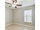 Simple bedroom features neutral-colored tile floors, large window with blinds, and overhead fan at 9437 Lemon Drop Loop, Sun City Center, FL 33573