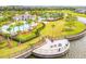 Aerial view of lakeside fire pit area with seating and lush landscaping at 9437 Lemon Drop Loop, Sun City Center, FL 33573