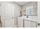 Functional laundry area with a washer, dryer, and a convenient storage shelf at 9437 Lemon Drop Loop, Sun City Center, FL 33573