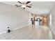 Open-concept living room with tile flooring that flows into the kitchen featuring white cabinetry at 9437 Lemon Drop Loop, Sun City Center, FL 33573
