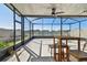 Spacious screened lanai features a ceiling fan, wooden table and seating, and gorgeous views of the pond at 9437 Lemon Drop Loop, Sun City Center, FL 33573