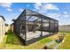 Wide shot of the screened lanai with its black aluminum frame and a view of the home's manicured backyard at 9437 Lemon Drop Loop, Sun City Center, FL 33573