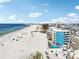 Aerial view showcases Island Inn condos with its pool alongside the pristine beach and beautiful ocean waters at 9980 Gulf Blvd # 408, Treasure Island, FL 33706