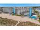 Aerial view of a beachfront condo with a pool, Tiki Bar, and beach volleyball court at 9980 Gulf Blvd # 408, Treasure Island, FL 33706