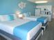 Well-appointed hotel room with two beds, a kitchenette, and a tastefully decorated wall at 9980 Gulf Blvd # 408, Treasure Island, FL 33706